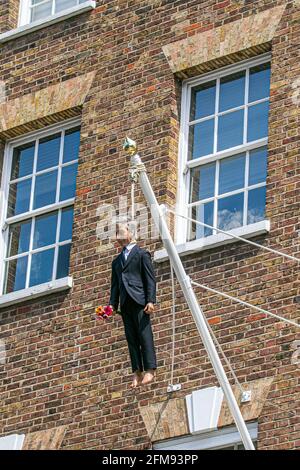 SAVILE ROW LONDON 7. MAI 2021. Eine Skulptur des italienischen Künstlers Maurizio Cattelan eines Mannes, der einen Blumenstrauß in der Savile Row London an einer Schlinge an einem Fahnenmast hält. Credit amer Ghazzal/Alamy Live News Stockfoto