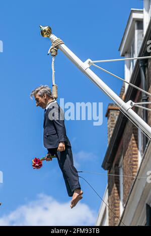 SAVILE ROW LONDON 7. MAI 2021. Eine Skulptur des italienischen Künstlers Maurizio Cattelan eines Mannes, der einen Blumenstrauß in der Savile Row London an einer Schlinge an einem Fahnenmast hält. Credit amer Ghazzal/Alamy Live News Stockfoto