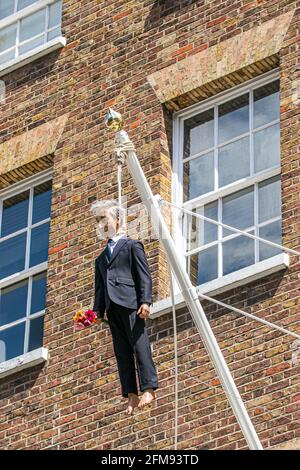 SAVILE ROW LONDON 7. MAI 2021. Eine Skulptur des italienischen Künstlers Maurizio Cattelan eines Mannes, der einen Blumenstrauß in der Savile Row London an einer Schlinge an einem Fahnenmast hält. Credit amer Ghazzal/Alamy Live News Stockfoto