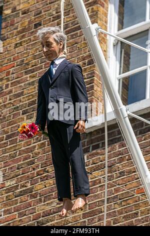 SAVILE ROW LONDON 7. MAI 2021. Eine Skulptur des italienischen Künstlers Maurizio Cattelan eines Mannes, der einen Blumenstrauß in der Savile Row London an einer Schlinge an einem Fahnenmast hält. Credit amer Ghazzal/Alamy Live News Stockfoto