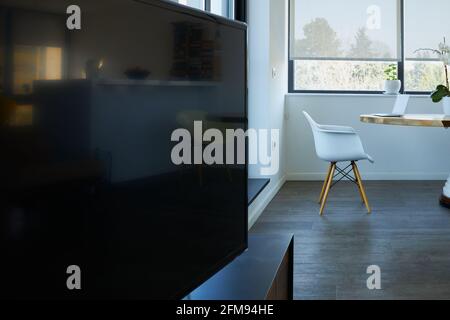 Großer Fernseher im Wohnzimmer mit kleinem Arbeitsbereich Eine exklusive Wohnung Stockfoto