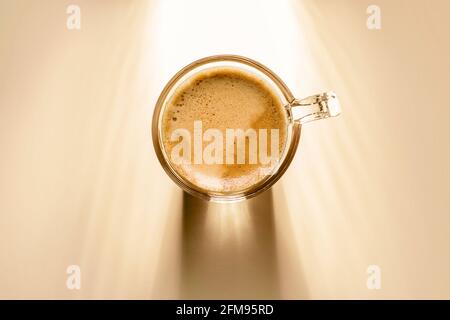 Kaffeetasse mit Rahmkaffee, Draufsicht auf Hintergrund mit Sonnenlicht. Stockfoto