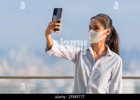 Asiatische Frau trägt Gesichtsmaske zum Schutz vor Coronavirus Covid-19 Horizontale Aufnahme Stockfoto