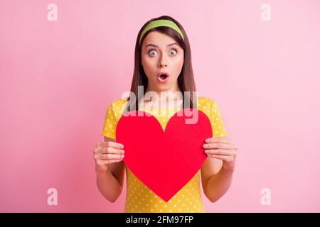 Foto von jungen attraktiv schockiert überrascht überrascht Mädchen halten groß Rote Herzunterdrückung isoliert auf rosa Hintergrund Stockfoto