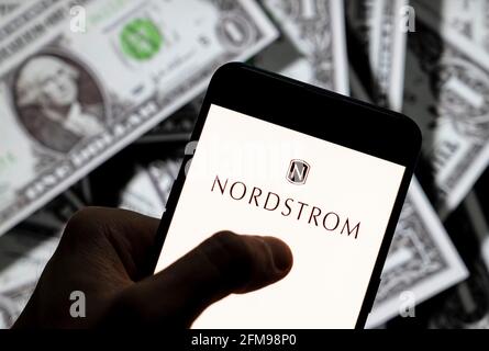 In dieser Abbildung ist das Logo der amerikanischen Kette des Luxusschmuckkaufhauses Nordstrom zu sehen, das auf einem Smartphone mit US-Dollar (USD) im Hintergrund angezeigt wird. Stockfoto