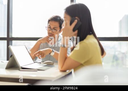 Zwei Kollegen aus der Wirtschaft arbeiten gemeinsam an einem neuen Projekt im Büro. Stockfoto