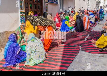UDAIPUR, INDIEN - 12. FEBRUAR 2017: Einheimische Frauen sitzen in einer Gasse in Udaipur, Rajasthan Staat, Indien Stockfoto