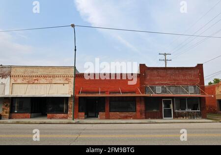 Leerstehende Schaufenster in historischen Backsteingebäuden säumen die Hauptstraße der Route 66 City of Commerce, Oklahoma. Stockfoto