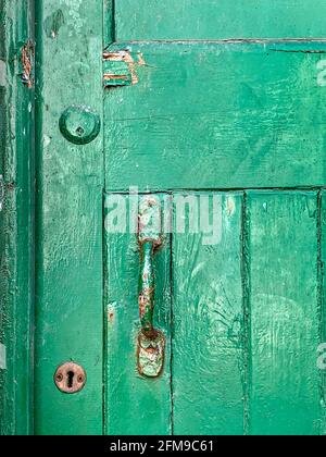 Grün lackierte Holztür mit Griff, Schlüsselloch und Schlüsselschloss Felge Zylinder Stockfoto