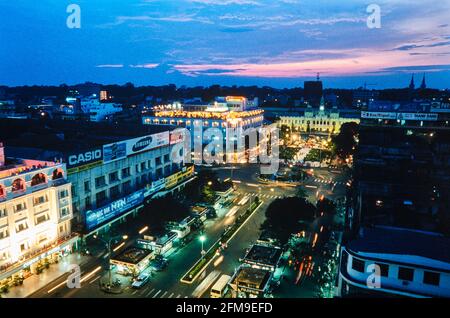 Nguyen Hue Street in Ho Chi Minh City bei Nacht mit dem Alten Rathaus am Ende der Straße und dem legendären Rex Hotel, auf der linken Seite am Verkehr Stockfoto