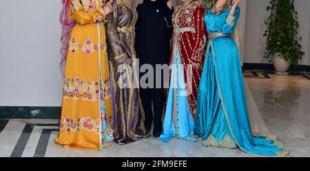 Eine Gruppe marokkanischer Models in Kaftanen. Der Kaftan ist ein langes, fließendes Kleid, das in Marokko oft getragen wird. Stockfoto