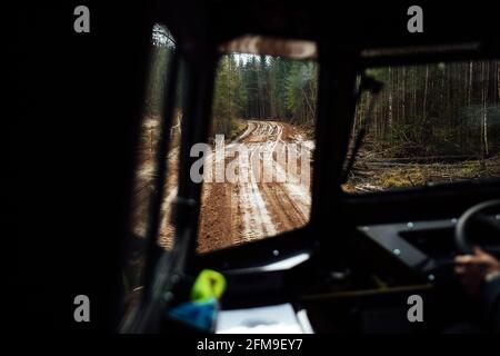 Blick aus dem Innenraum des SUV auf dem Gelände. Reisen Sie durch die wilden Plätze mit dem Auto mit hohem Verkehr. Blick vom Beifahrersitz auf den Fahrer Stockfoto