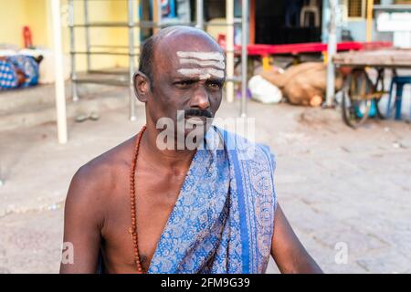 Mysuru, Karnataka, Indien - Januar 2019: Porträt eines hinduistischen Tempelpriesters in ethnischer Kleidung mit gestreifter heiligem Asche auf seiner Stirn im uralten Sturm Stockfoto