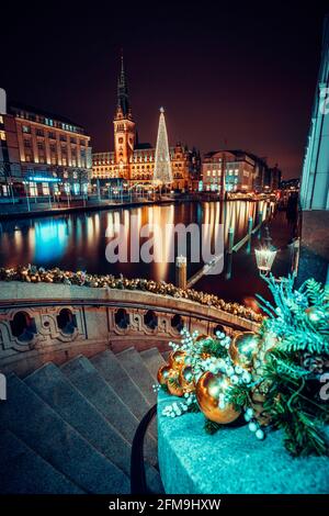 Weihnachtszeit bei Alsterfleet und dem Rathaus in Hamburg bei Nacht. Wunderschön beleuchtete Innenstadt, Stadtzentrum. Stockfoto