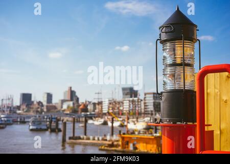 Rotlichtlaterne in der HafenCity, Hafenpiers mit Schiffen und Jacht vor Anker im Hintergrund. Hamburg, Deutschland. Stockfoto