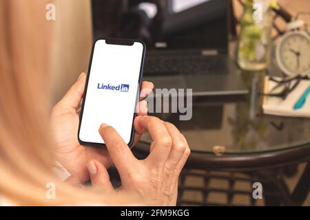 Charkow, Ukraine - 27. April 2021: Frau nutzt Mobiltelefon mit LinkedIn App auf dem Bildschirm Stockfoto