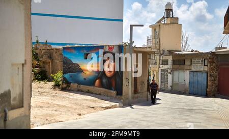 PAPHOS, ZYPERN - 21. Aug 2019: Einsamer Mensch in einer emtey Straße mit Graffiti Stockfoto