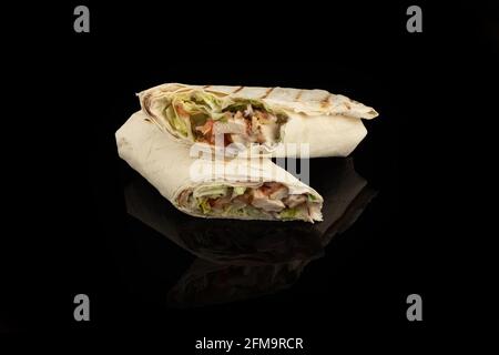 Klassische Shawarma Kebab Pita mit Huhn und Gemüse und Sauce auf schwarzem Hintergrund. In Abschnitt Stockfoto