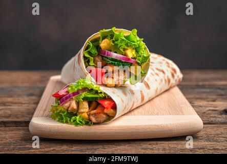 Traditionelle orientalische Shawarma Nahaufnahme auf braunem Hintergrund. Seitenansicht, Kopierbereich. Stockfoto