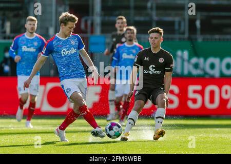 Kiel, Deutschland. Mai 2021. Fußball: 2. Bundesliga, Holstein Kiel - FC St. Pauli, Matchday 32, im Holsteinstadion. Der Kieler Johannes van den Bergh (l) und der St. Paulis Finn Ole Becker kämpfen um den Ball. Kredit: Frank Molter/dpa - WICHTIGER HINWEIS: Gemäß den Bestimmungen der DFL Deutsche Fußball Liga und/oder des DFB Deutscher Fußball-Bund ist es untersagt, im Stadion und/oder vom Spiel aufgenommene Fotos in Form von Sequenzbildern und/oder videoähnlichen Fotoserien zu verwenden oder zu verwenden./dpa/Alamy Live News Stockfoto