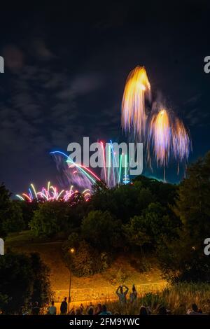 Fröhliche Menschen beobachten das Feuerwerk am Abendhimmel Stockfoto