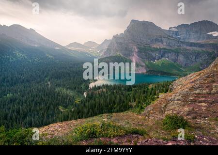 Sehr bewölktes Wetter über dem unteren Grinnell Lake im Glacier National Park, Montana, USA. Wandern auf dem Grinnell Glacier Trail in den amerikanischen Rockies. Hohe Spitzen, w Stockfoto