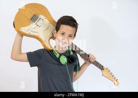 Ein kleiner Junge singt und spielt lächelnd auf der E-Gitarre, isoliert auf weißem Hintergrund Stockfoto