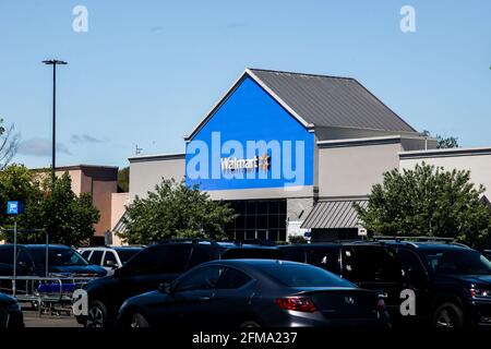 NORWALK, CONNECTICUT - 6. MAI 2021: Walmart-Ladenschild mit blauem Himmel und Autos auf dem Parkplatz Stockfoto