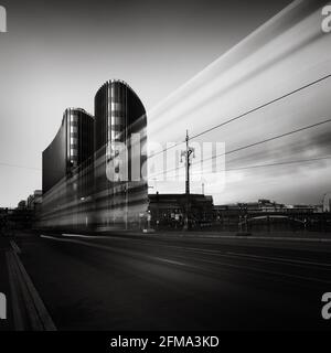 Fahrende Straßenbahn am Bürogebäude in der Berliner Friedrichstraße in Schwarz-Weiß. Stockfoto