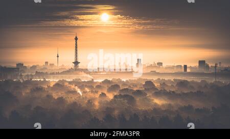 Sonnenaufgang im Herbst über dem nebligen Grunewald mit Blick auf den Funkturm und den Fernsehturm in Berlin. Stockfoto