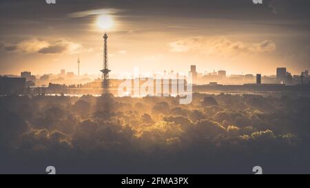 Sonnenaufgang im Herbst über dem nebligen Grunewald mit Blick auf den Funkturm und den Fernsehturm in Berlin. Stockfoto