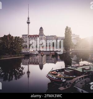 Spiegelung der Spree bei Sonnenaufgang am historischen Hafen mit Fernsehturm und Altstadthaus in Berlin. Stockfoto