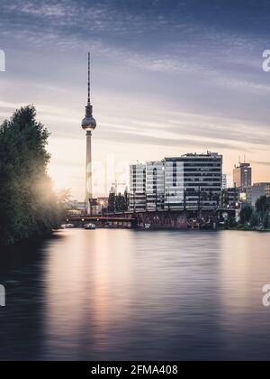Sonnenuntergang auf der Spree mit Blick auf den Berliner Fernsehturm und die Trias-Türme. Stockfoto