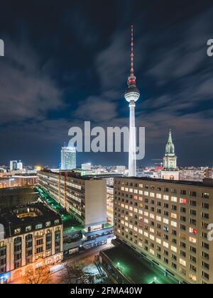 Blick auf den beleuchteten Berliner Fernsehturm, den Alexanderplatz und die Marienkirche bei Nacht. Stockfoto