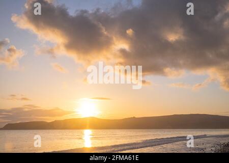 Sonnenuntergang, Sonnenuntergang, Sonne, at, Port Neigwl, Porth Neigwl Beach, auch bekannt als, aka, Hell's Mouth, dramatisch, Wolke, Wolken, auf, beliebt, Surfen, Surfen, Strand, Meer, Meer, Dorf, Westen, Mitte, Nordwales,, County, Welsh Sommerurlaub, Aufenthalt, Resort.Vereinigtes Königreich, GB, Europa.Porth Neigwl, auch bekannt in Englisch, als "3 breite Küste von Wales, Llŷn Meilen auf der Halbinsel. Die Bucht liegt südwestlich und liegt zwischen den Landzungen von Mynydd Rhiw im Westen und Mynydd Cilan im Osten Stockfoto