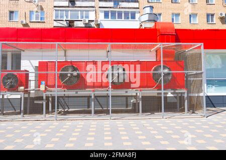 Große rote industrielle Klimaanlagen hängen an der Wand von Das Supermarktgebäude Stockfoto