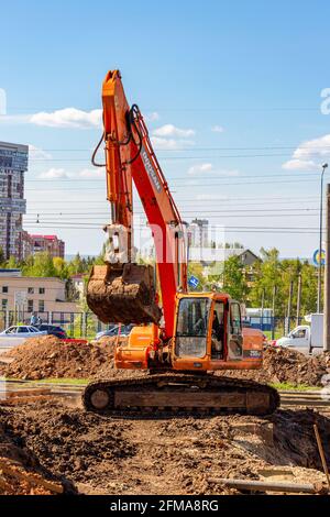 Samara, Russland - 06. Mai 2021: Orangefarbener Bau-Einkübel-Raupenbagger im Sommer Stockfoto