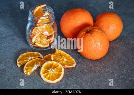 Frisches Obst Orangen und Orangenscheiben dehydriert und in Glasbehältern gelagert, hausgemachte Zubereitungen, Stockfoto