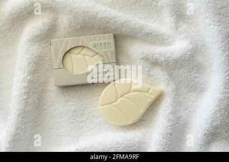 Little Switzerland, NC - 22. April 2021: Umweltfreundliche Hotelausstattung Green Natura Seife in der Box und auf einem weißen Frottee-Handtuch sitzend Stockfoto