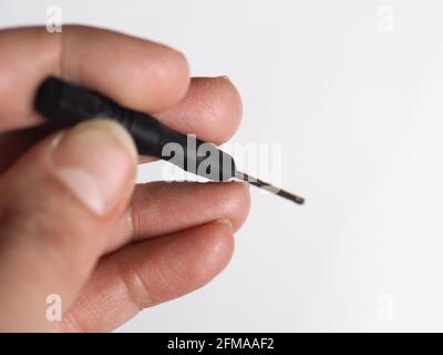 Hand hält kleinen Sternschrauber über weißem Hintergrund Stockfoto