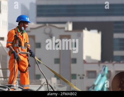 Blick auf die Arbeit der Arbeitnehmer unter heißen Wetterbedingungen in Doha, Katar. Stockfoto