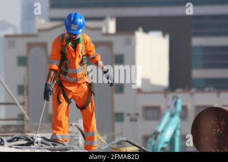 Blick auf die Arbeit der Arbeitnehmer unter heißen Wetterbedingungen in Doha, Katar. Stockfoto