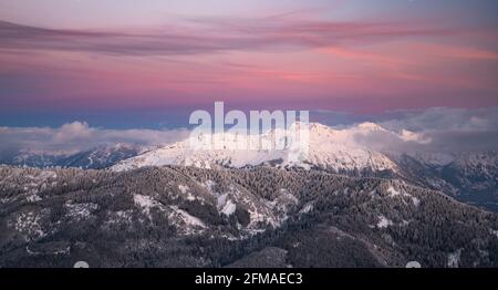 Winterlich verschneite Berglandschaft nach Sonnenuntergang. Bunte Wolken über Kühgundkopf und Iseler. Allgäuer Alpen, Bayern, Deutschland, Europa Stockfoto