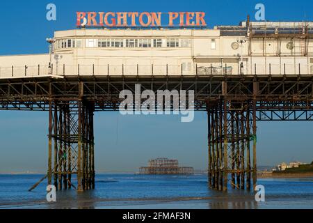 Der verfallene West Pier von Brighton wurde in die Struktur des „Brighton Pier“, des Palace Pier, eingefasst. Stockfoto