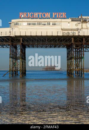 Der verfallene West Pier von Brighton wurde in die Struktur des „Brighton Pier“, des Palace Pier, eingefasst. Stockfoto