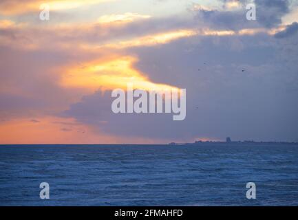 Blick von Brighton in Richtung Worthing, mit der Silhouette des Worthing Piers am Horizont. Sussex, England Stockfoto