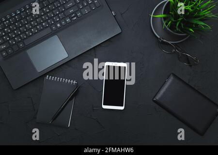 Business-Accessoires auf Graphithintergrund. Business, Fernarbeit, Selbststudienkonzept. Draufsicht, flach liegend, Low-Key. Stockfoto
