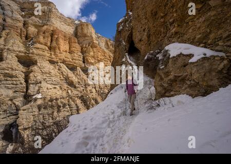 Junge Frau wandert durch einen Canyon in der Nähe von Ghyakar in Upper Mustang, Nepal Stockfoto