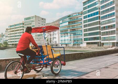 Taxy Bike - Dreiradtaxi auf dem Boulevard am Pier in Ancon, Peru, sonniger Tag. Neues normales Konzept Stockfoto