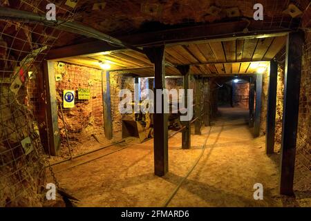 Tennant Creek, Australien - 2019. Aug: Unterirdische Höhle mit Steinbrecherwagen auf der Eisenbahn im Battery Hill Mining Center Museum, während der Führung. Stockfoto